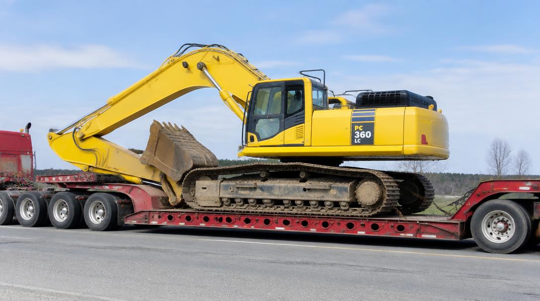 Excavator loaded on a lowboy heavy equipment trailer
